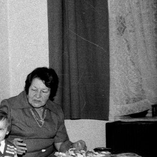 Family sharing meal indoors during the 1970s-80s.
