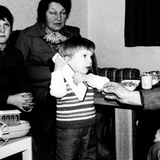 Family gathering around a birthday cake.