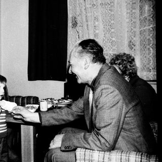 Family gathering around a birthday cake.