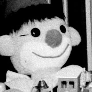 Young child playing with toy train and doll.
