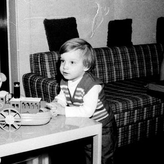 Young child playing with toy train and doll.