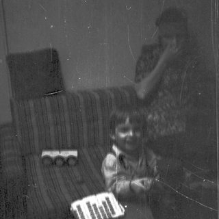 Child playing with toy train on couch.