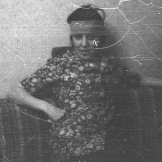 Vintage photo of elderly person in patterned clothing.