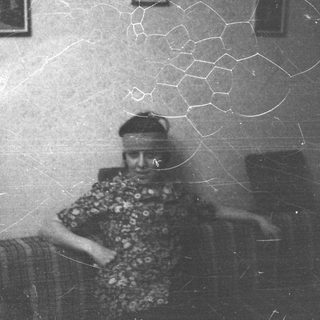 Vintage photo of elderly person in patterned clothing.