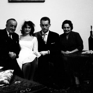Family posing indoors during a wedding celebration.