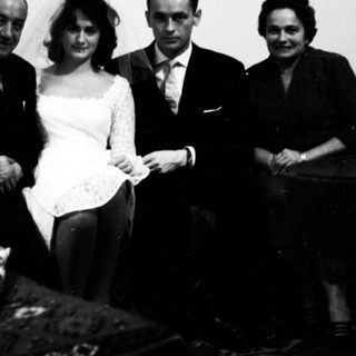 Family posing indoors during a wedding celebration.