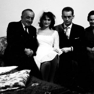 Family posing indoors during a wedding celebration.
