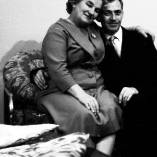 Four people posing together indoors, mid-20th century.