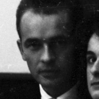 Couple seated at a piano, formal attire.