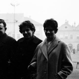 Four individuals posing together outdoors in mid-20th-century attire.