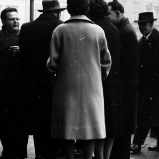 Group of people in formal attire gathered outdoors.