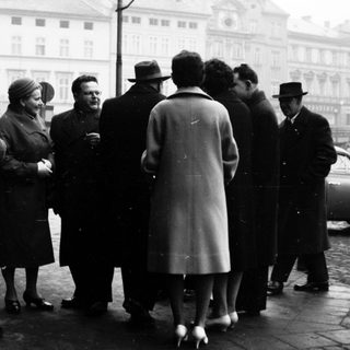 Group of people in formal attire gathered outdoors.