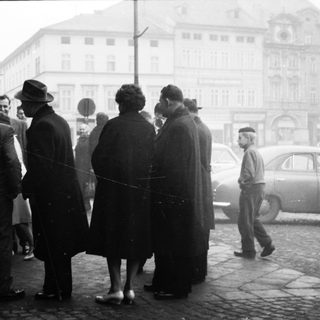People queuing outside in a city street.