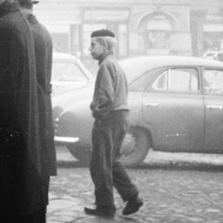 People queuing outside in a city street.