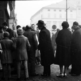 People queuing outside in a city street.