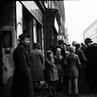 People queuing outside a building during post-war period.