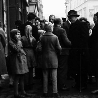 People queuing outside a building during post-war period.