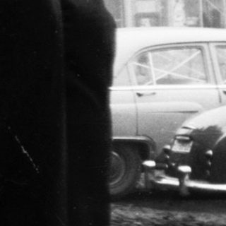 People queuing outside a building during post-war period.