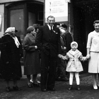 Family posing outside a train station.