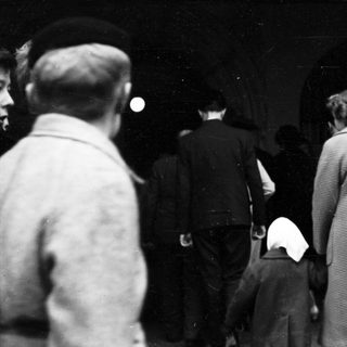 People standing in line outdoors at night.
