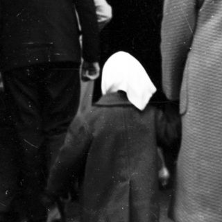 People standing in line outdoors at night.