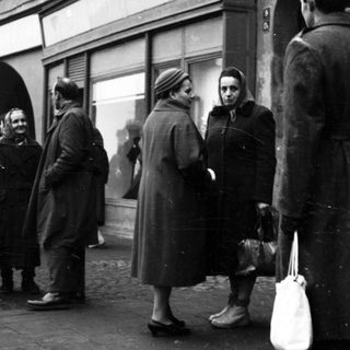 People queuing outside a store during mid-20th century.