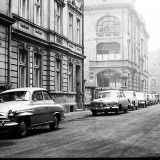 Vintage street scene with parked vintage cars.