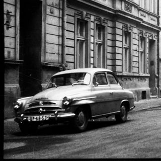 Vintage street scene with parked vintage cars.