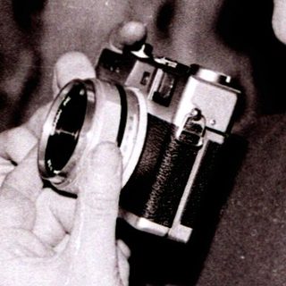 Person holding vintage camera indoors.