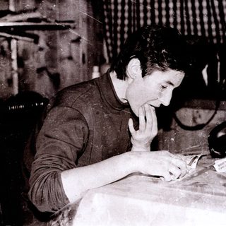 Man intently working on detailed craft or sewing.