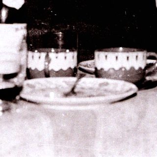 Old man toasting at a formal dinner table.