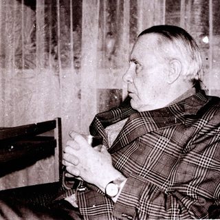 Old man sitting thoughtfully in vintage interior.