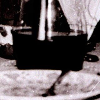Two elderly women seated indoors at a table.