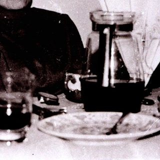 Two elderly women seated indoors at a table.