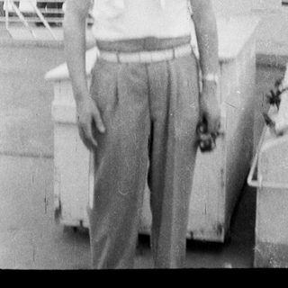 Person standing on dock near ship.