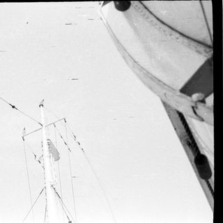 Person ascending tall structure with ropes.