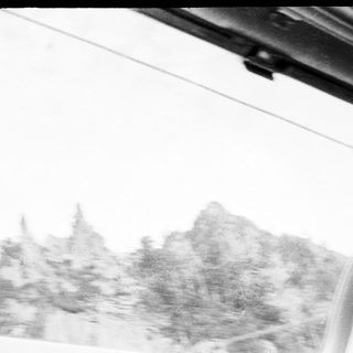 Blurry mountain view from inside vehicle.
