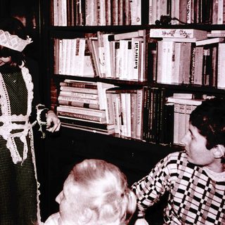 Magician performing trick with handkerchief in library setting.