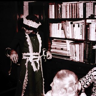Magician performing trick with handkerchief in library setting.