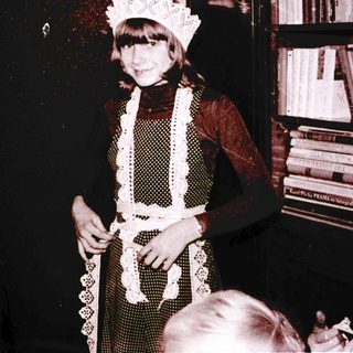 Young girl dressed as a maid in vintage photo.