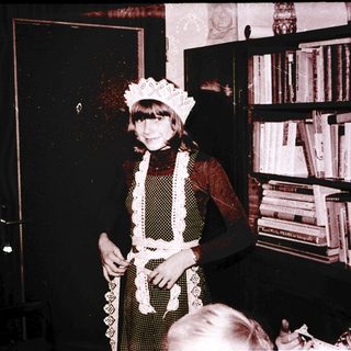 Young girl dressed as a maid in vintage photo.