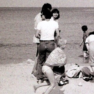 People playing and relaxing on a beach.