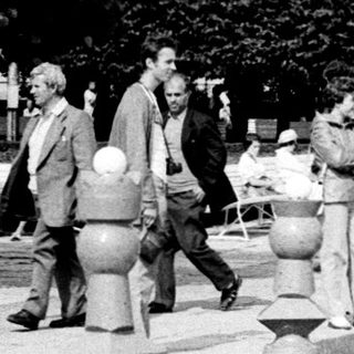 Large outdoor chess game with people playing.