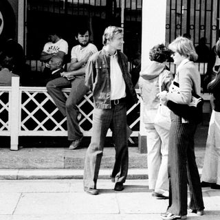 Group of people waiting outside a building entrance.