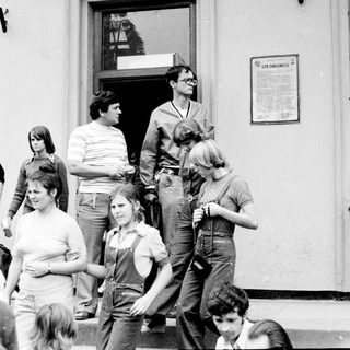 Group of people gathered outside a building entrance.