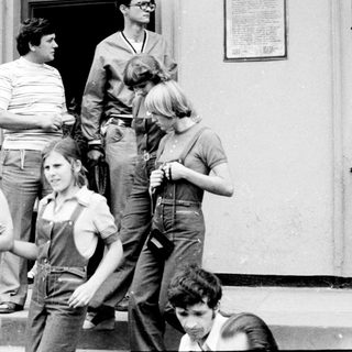 Group of people gathered outside a building entrance.
