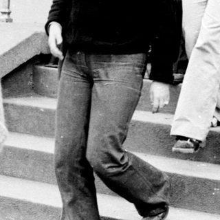 People exiting building during 1970s era.