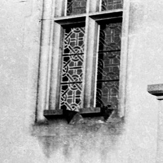 Two people leaning on a balcony railing.