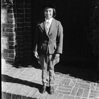 Young man in suit posing outdoors.