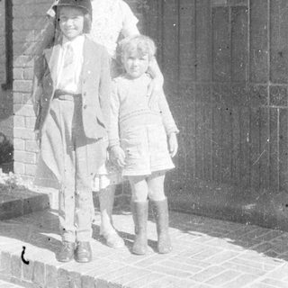Family portrait with three children and adult outdoors.